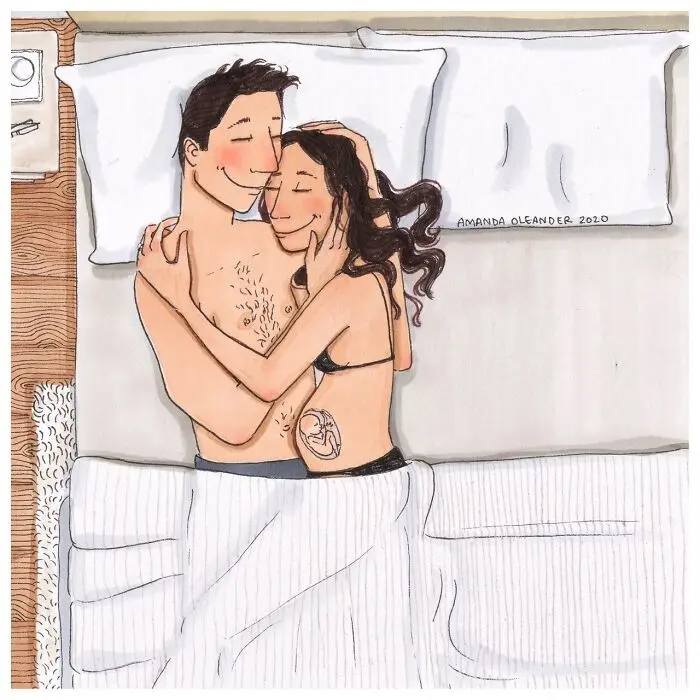 Illustration by Amanda Oleander of an expecting couple lying in bed embracing tenderly, with a visible fetus drawing on the mother's belly symbolizing pregnancy, love, and the intimate anticipation of motherhood.
