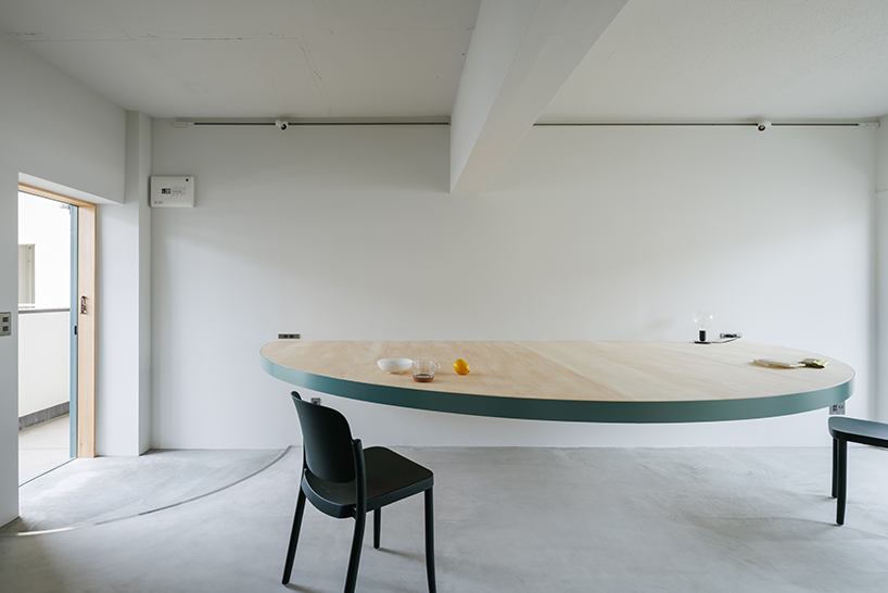 giant blue-green semicircular table by tato architects reorganizes kyoto apartment - 1