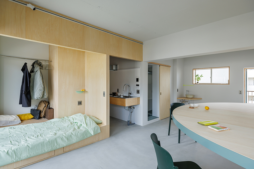 giant blue-green semicircular table by tato architects reorganizes kyoto apartment - 2