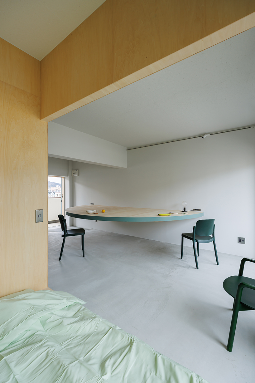 giant blue-green semicircular table by tato architects reorganizes kyoto apartment - 3