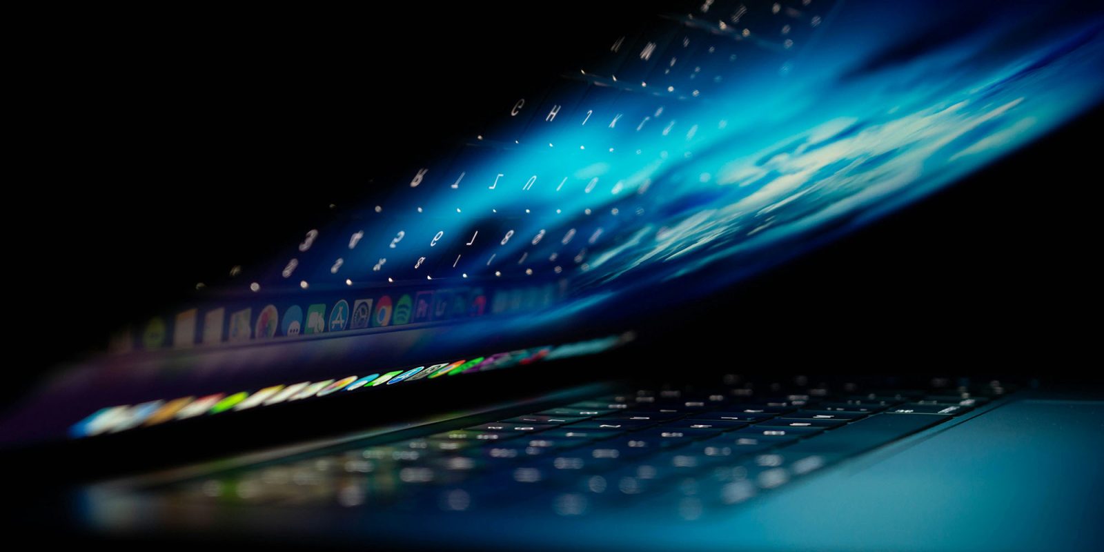 Pazite na lažna izvješća o padu Maca | Slika prikazuje djelomično otvoren MacBook s apstraktnom plavom grafikom