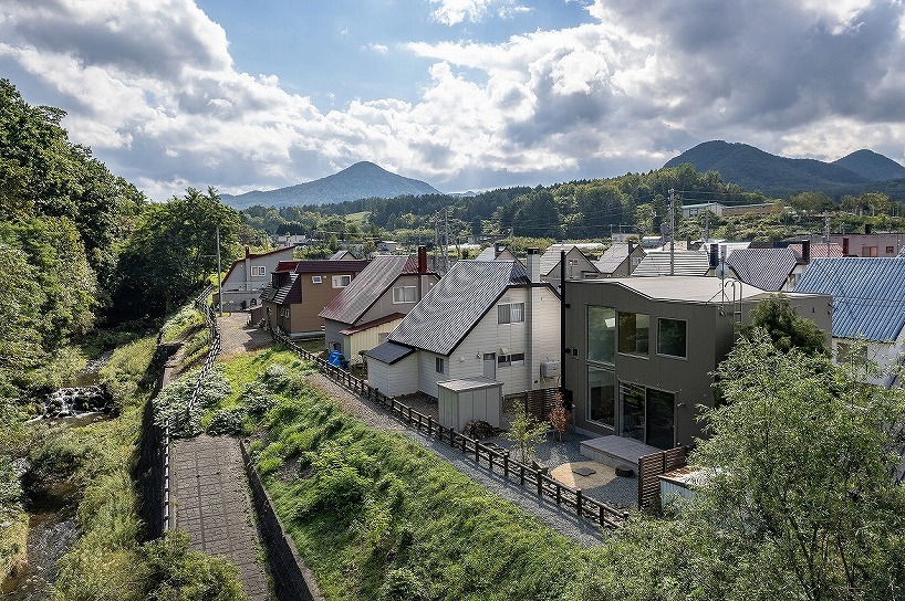 split-level timber house organizes layered interiors around japanese forest landscape - 1