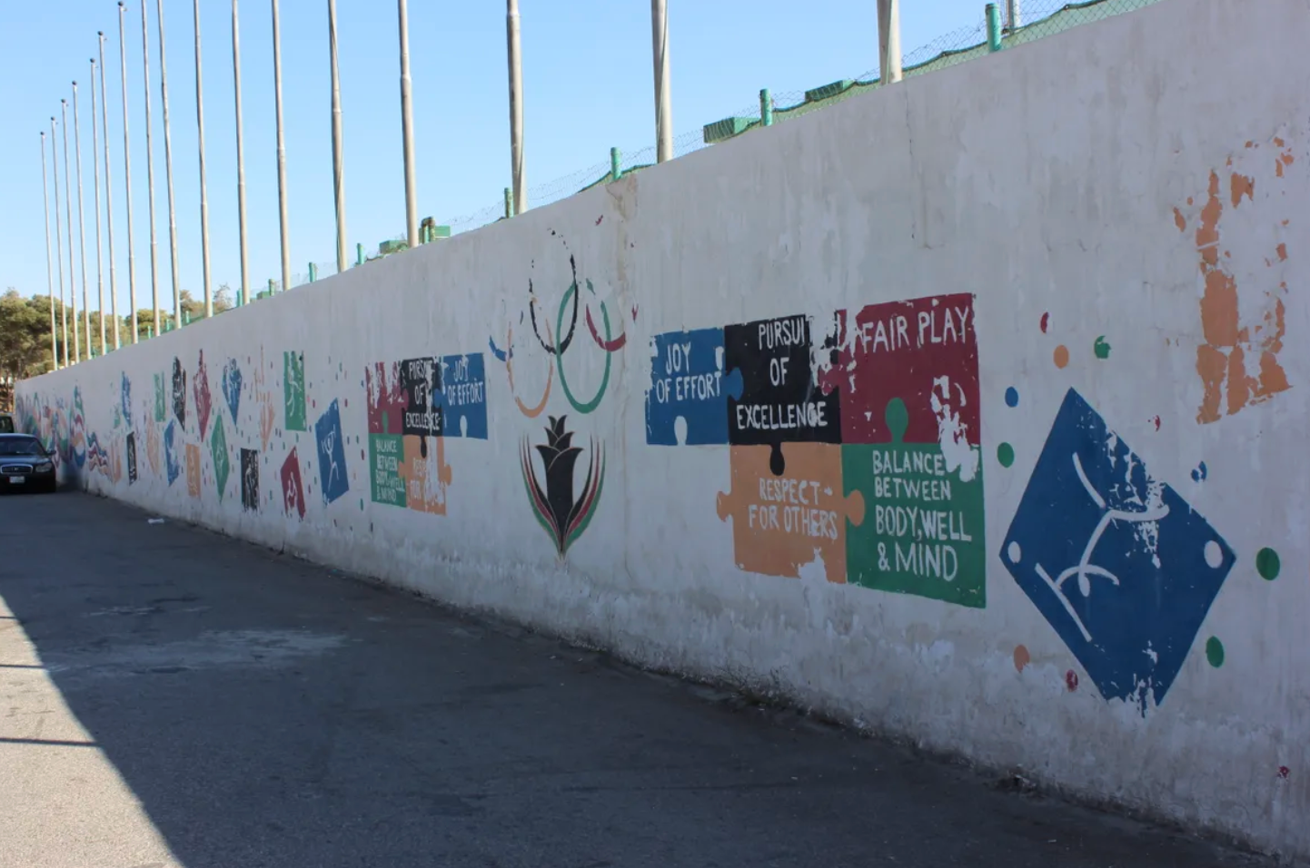 Colorful messages of sportsmanship fade on Sports City's walls. 